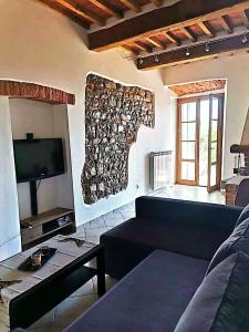 een woonkamer met een bank en een tv aan de muur bij La Dormeuse in Lucignano