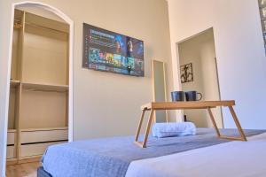 a bedroom with a table on a bed with a tv on the wall at [MONZA-CENTRO] Modern Flat Near Train Station in Monza