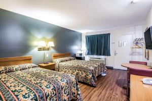 a hotel room with two beds and a television at Rodeway Inn North Chesterfield-Richmond in Richmond