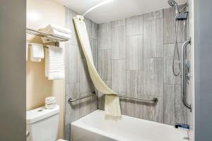 een badkamer met een wit bad en een toilet bij Rodeway Inn North Chesterfield-Richmond in Richmond