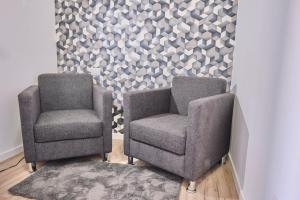 two chairs sitting next to each other next to a wall at [MONZA-CENTRO] Modern Flat Near Train Station in Monza +9 photos