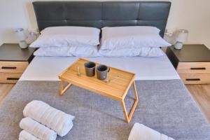 a bed with two pillows and a coffee table at [MONZA-CENTRO] Modern Flat Near Train Station in Monza