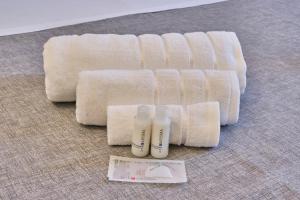 a group of white towels and two bottles of shampoo at [MONZA-CENTRO] Modern Flat Near Train Station in Monza