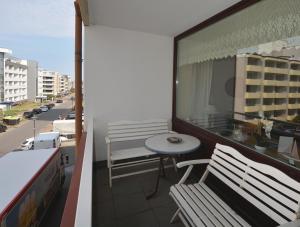 einen Balkon mit zwei Bänken und einem Tisch auf einem Gebäude in der Unterkunft 13-36, sehr Strandnah, im Herzen Westerlands, Westbalkon, 1 Zi in Westerland