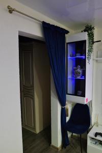 Zimmer mit einem blauen Vorhang und einem Stuhl in der Unterkunft Apartament in the City Center in Rokiškis