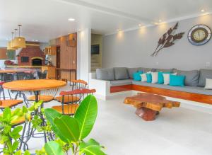 uma sala de estar com um sofá e uma mesa em Apto c piscina e WiFi a 150m da Praia de Mundaí - BA em Porto Seguro