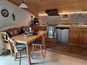 eine Küche mit einem Holztisch sowie einem Tisch und Stühlen in der Unterkunft Ferienwohnung am Wirtshof in Siegsdorf
