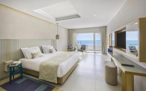 a hotel room with a bed and a view of the ocean at Royal Azur Thalassa in Hammamet