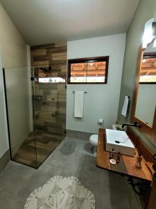 a bathroom with a glass shower and a sink at Recanto da Natureza in Brotas