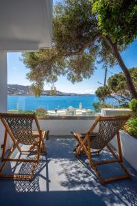two chairs on a patio with a view of the ocean at Hotel Adonis in Mikonos