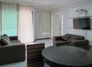 uma sala de estar com um sofá e uma mesa em Apto c piscina e WiFi a 150m da Praia de Mundaí - BA em Porto Seguro