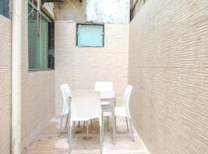 uma mesa e cadeiras em frente a uma parede de tijolos em Apto c piscina e WiFi a 150m da Praia de Mundaí - BA em Porto Seguro