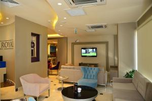 a waiting room with a couch and chairs and a tv at Hotel Star Royal in Igdır