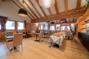 comedor con mesas y sillas y techos de madera en Alagna Mountain Resort & SPA en Alagna Valsesia