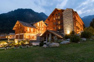a large wooden building with a mountain in the background at Alagna Mountain Resort & SPA in Alagna Valsesia