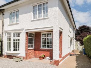 a white house with white windows and a driveway at St Botolphs in Hornsea