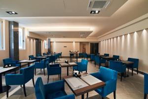 フォリーニョにあるHotel Poledriniのダイニングルーム(テーブル、青い椅子付)