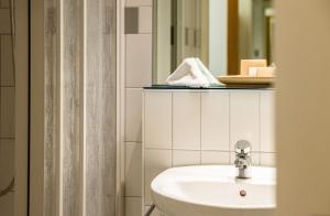 a bathroom with a sink and a mirror at ODELYA - Stadthotel im Park in Basel