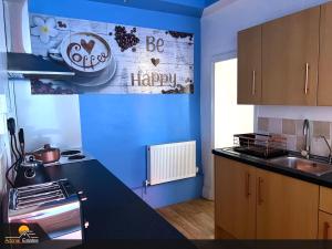 eine Küche mit einer blauen Wand und einer Arbeitsplatte in der Unterkunft Priorswood House in Taunton