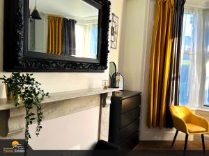 ein Badezimmer mit einem Spiegel, einem Waschbecken und einem Stuhl in der Unterkunft Priorswood House in Taunton