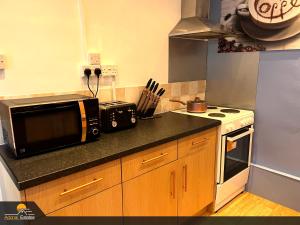 a kitchen with a microwave and a stove at Priorswood House in Taunton