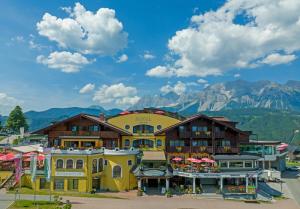 a group of buildings with mountains in the background at Hotel Erlebniswelt Stocker in Schladming
