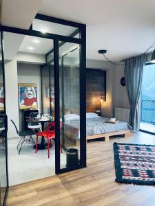a bedroom with a bed and a desk and a table at Kazbegi Stylish Apartment in Stepantsminda