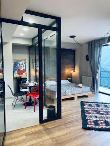 una camera da letto con un letto, una scrivania e un tavolo di Kazbegi Stylish Apartment a Kazbegi