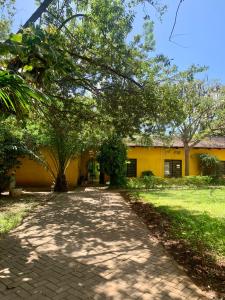 una pasarela frente a un edificio amarillo en Baobab Village Studio, en Dar es Salaam