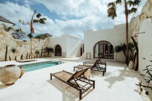 a villa with a swimming pool and palm trees at Casa Viamo in Canggu