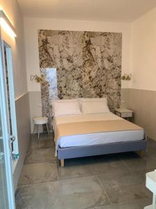 een slaapkamer met een bed en een muur bij San Pietro Home in San Pietro in Bevagna