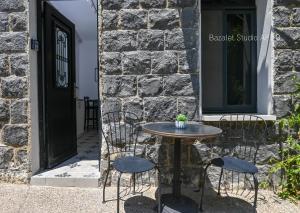 Puy Bazelet Apartments في طبرية: طاولة وكراسي أمام المبنى