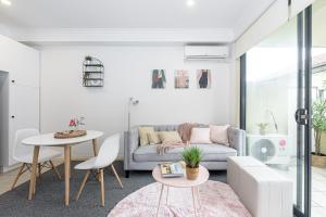 uma sala de estar com um sofá e uma mesa em Cozy 1 bedder in St Kilda with Balcony em Melbourne