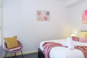 um quarto com 2 camas e uma cadeira em Cozy 1 bedder in St Kilda with Balcony em Melbourne