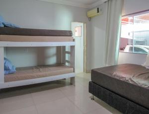 a bedroom with two bunk beds and a window at Lazer completo ao lado da praia em Porto Seg - BA in Porto Seguro