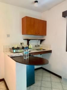 a kitchen with a counter with two water bottles on it at Baobab Village Studio in Dar es Salaam