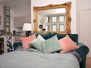 a green couch with pillows in front of a mirror at The Sandpiper's Pearl in Nottage