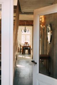 a hallway leading to a dining room with a table at Kalnciema kvartāla Kuldīgas rezidence in Kuldīga