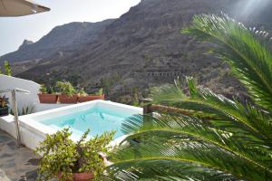 une piscine avec une montagne en arrière-plan dans l'établissement Casa pitita, à Maspalomas