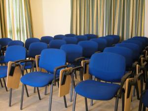 a row of blue chairs in a room at Rivotorto Retreat House in Birkirkara