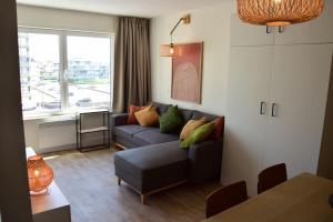 a living room with a couch and a window at HHVDK aan zee in Oostduinkerke
