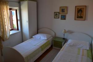 a bedroom with two beds and a window at Family friendly apartments with a swimming pool Sutivan, Brac - 14737 in Sutivan