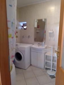 a bathroom with a washing machine and a sink at Family friendly apartments with a swimming pool Sutivan, Brac - 14737 in Sutivan