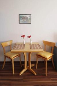 キュールングスボルンにあるYachthafenresidenz-Wohnung-9203-894の木製テーブル(椅子2脚付)と花のテーブル