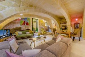 a large living room with a stone wall at The Valley Holiday Home in Kerċem