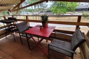 een rode tafel en stoelen op een terras bij Douar ha mor in Locoal-Mendon