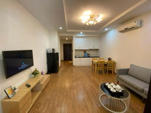 a living room with a couch and a tv and a table at Vinhomes Times City 1BR in Hanoi
