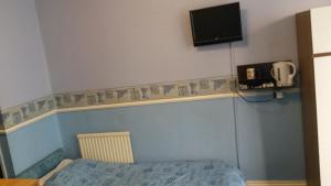 a bedroom with a bed and a tv on the wall at Walford Hotel in Blackpool