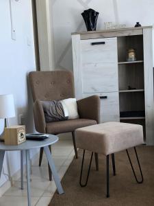 a living room with a chair and a table at Panoramic Holidays - Superior 17 in Peyia