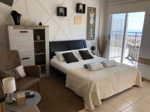 a bedroom with a large bed and a chair at Panoramic Holidays - Superior 17 in Peyia